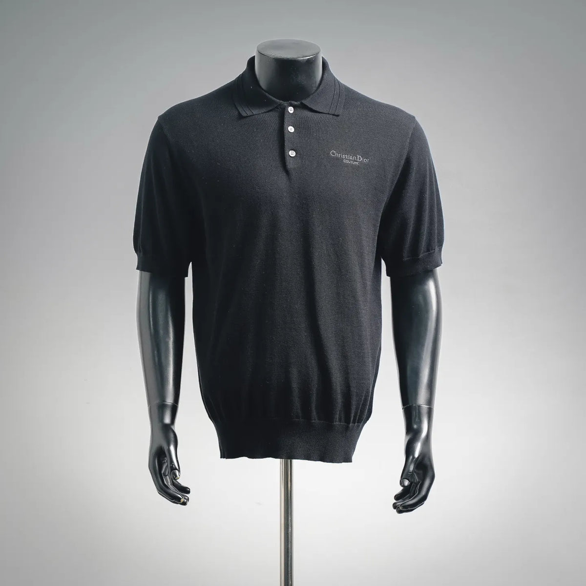 Black short-sleeve polo knit shirt with buttoned placket and small chest logo