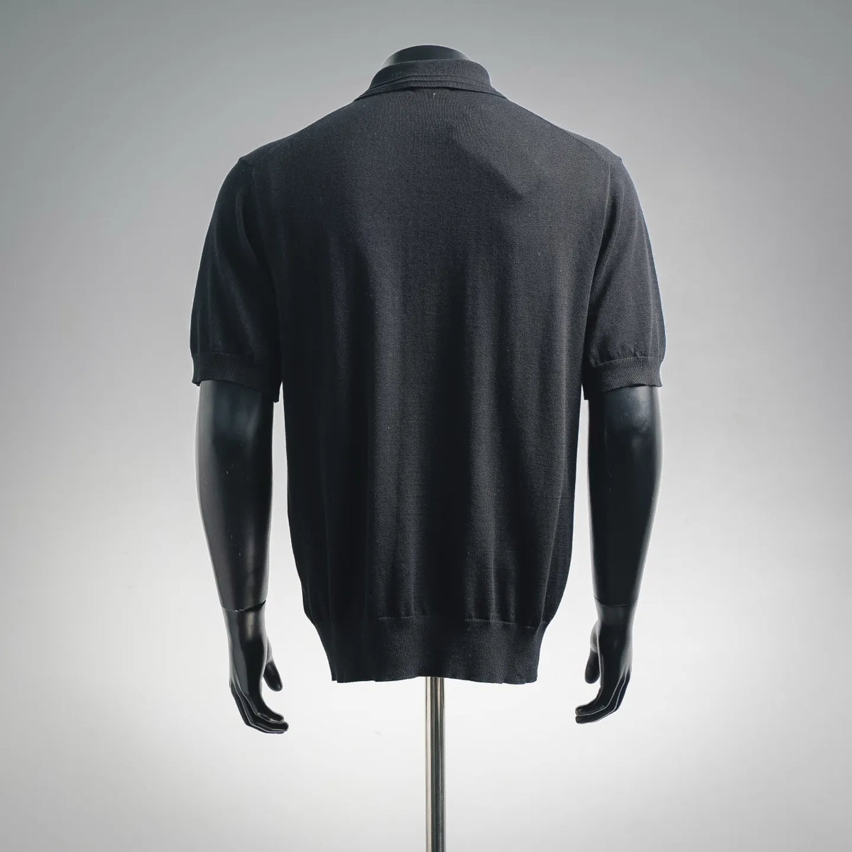 Black short-sleeve polo knit shirt, back view with ribbed hem and cuffs