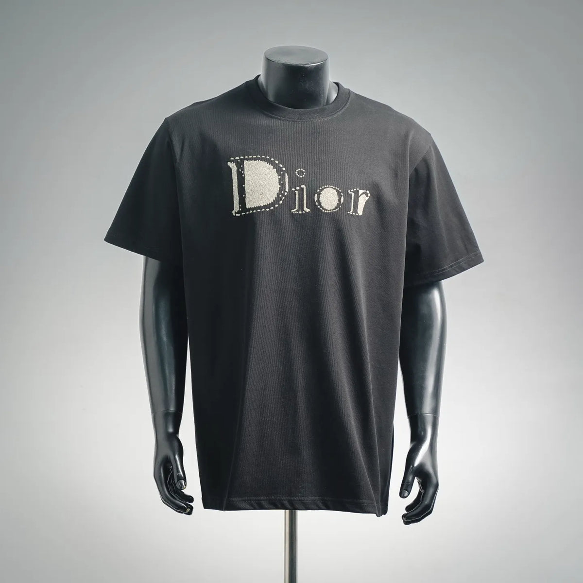 Dior short-sleeve T-shirt in dark color with large jeweled “Dior” logo on front