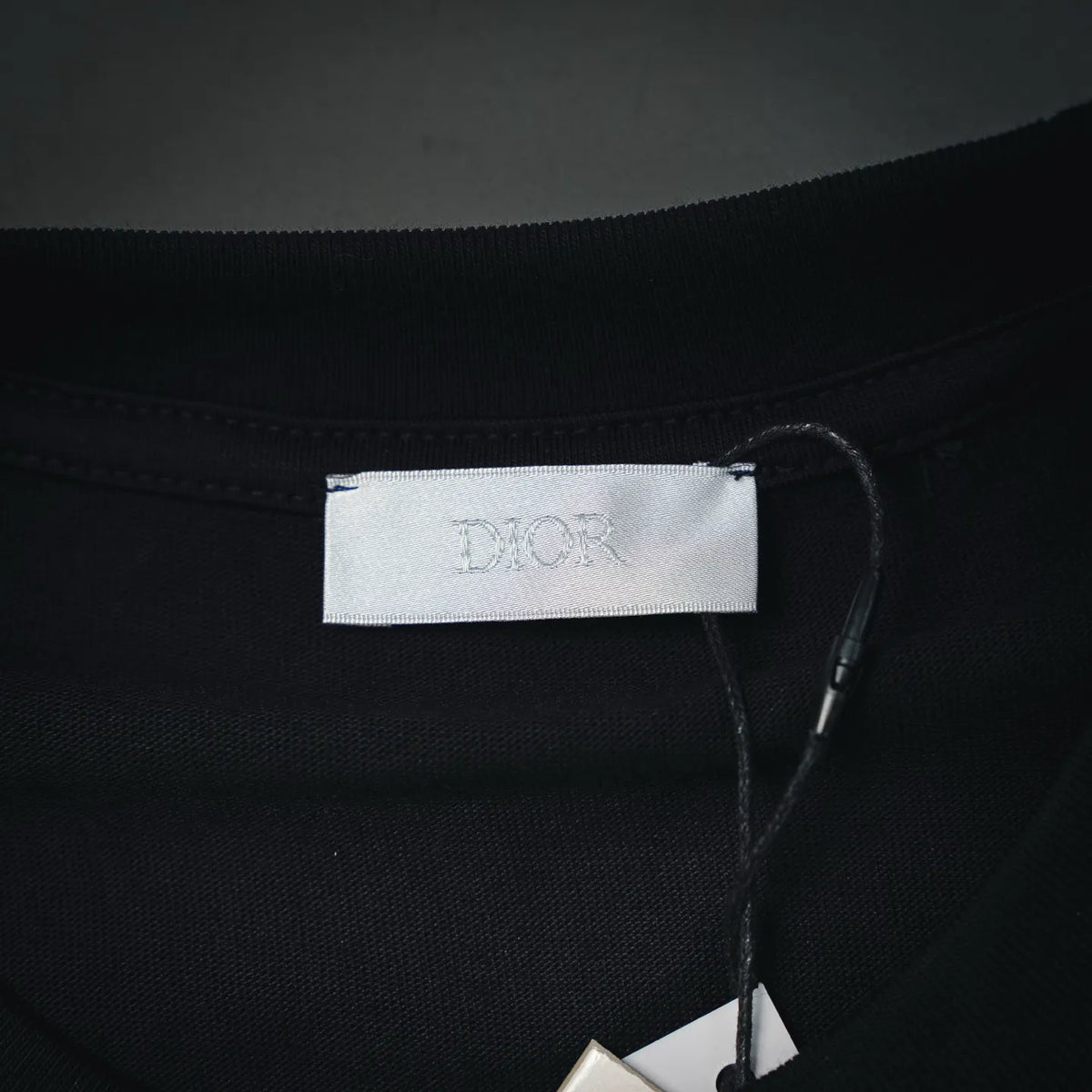 Dior neck label inside dark T-shirt with stitched neckline seam