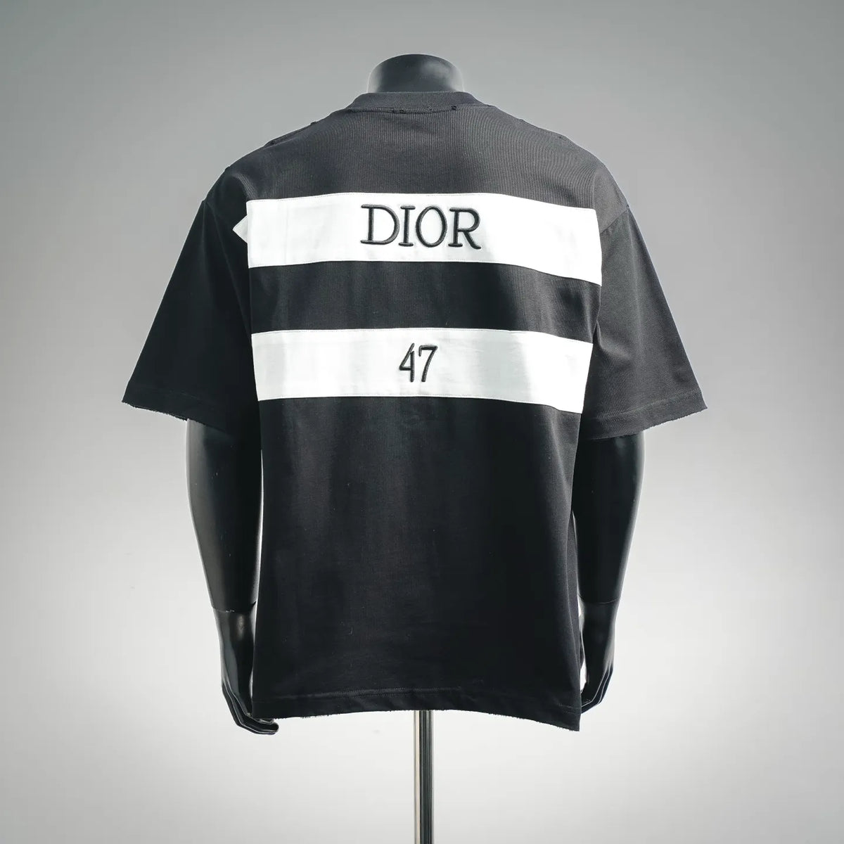 Dark Dior T-shirt back with white stripe panel and 'DIOR 47' graphic.