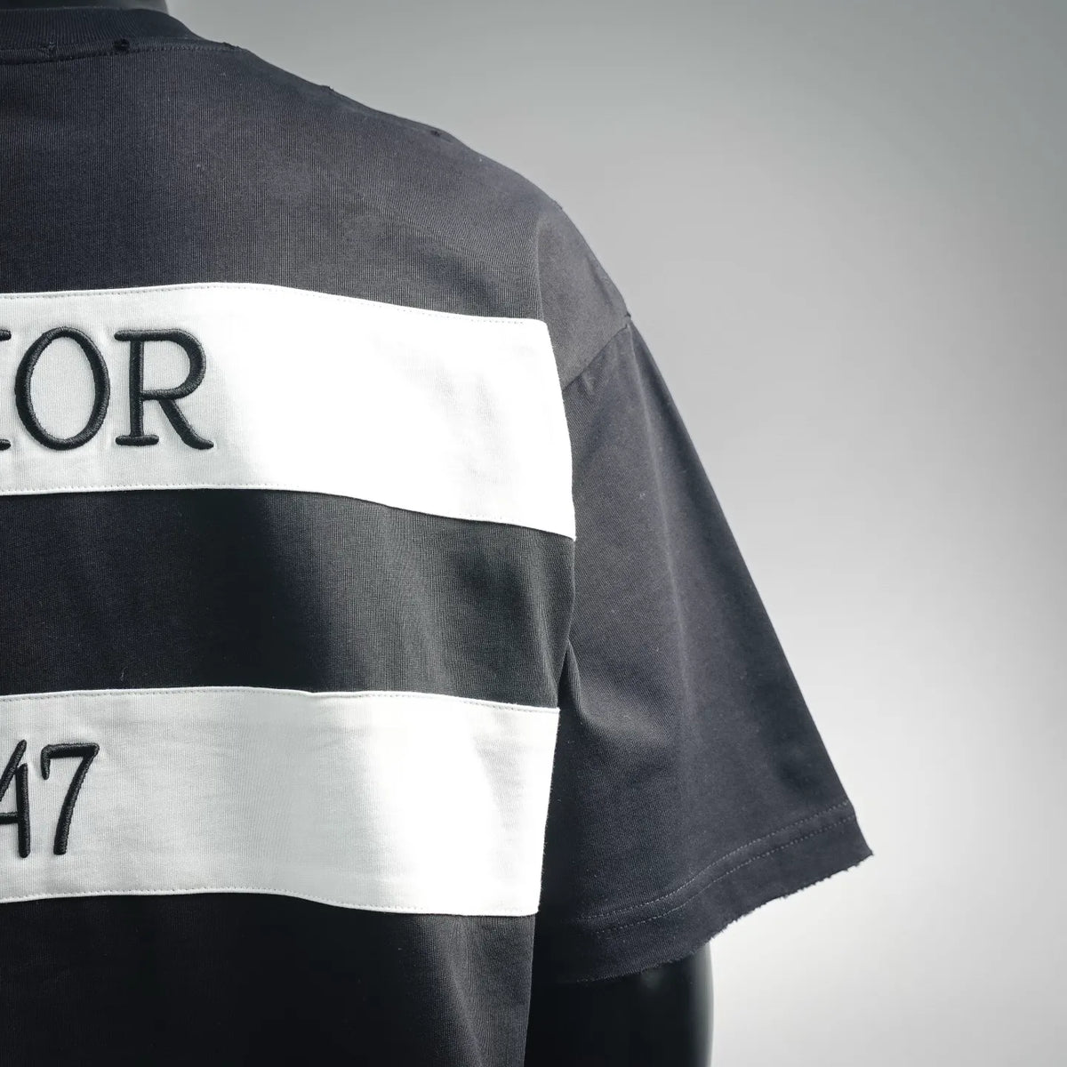 Dark Dior T-shirt with white stripe across back and short sleeve.