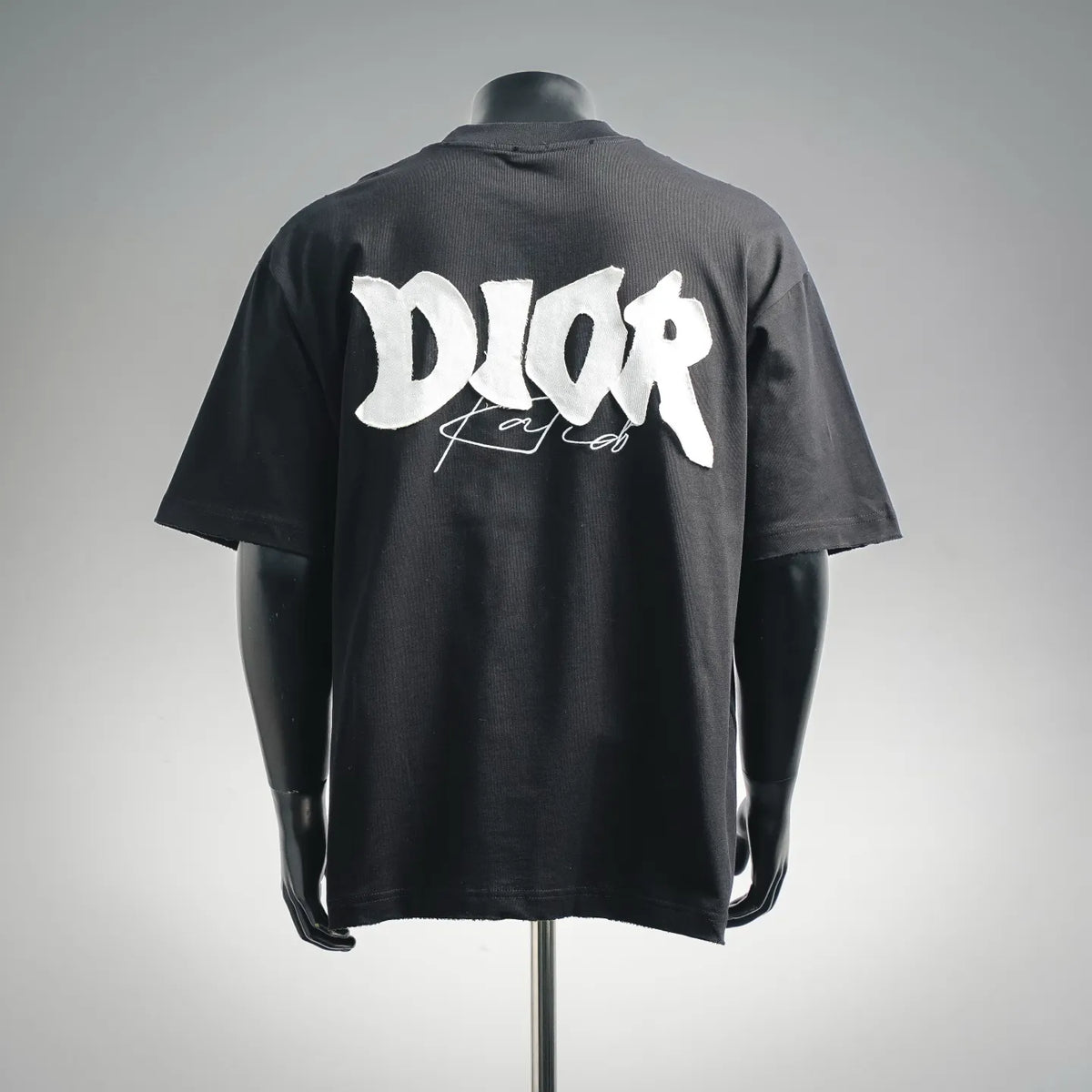 Black short-sleeve T-shirt with large white Dior logo graphic on the back