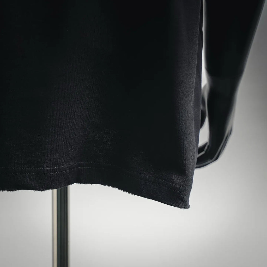 Black short-sleeve T-shirt hem with visible stitching and drape over a mannequin