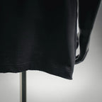 Black short-sleeve T-shirt hem with visible stitching and drape over a mannequin
