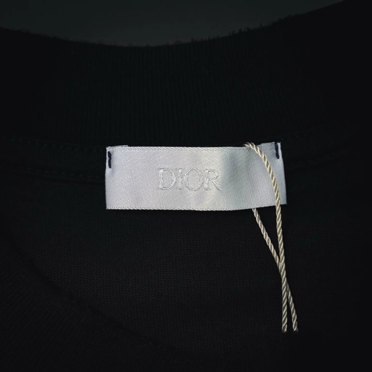 Inside neck tag with “Dior” label on black short-sleeve T-shirt