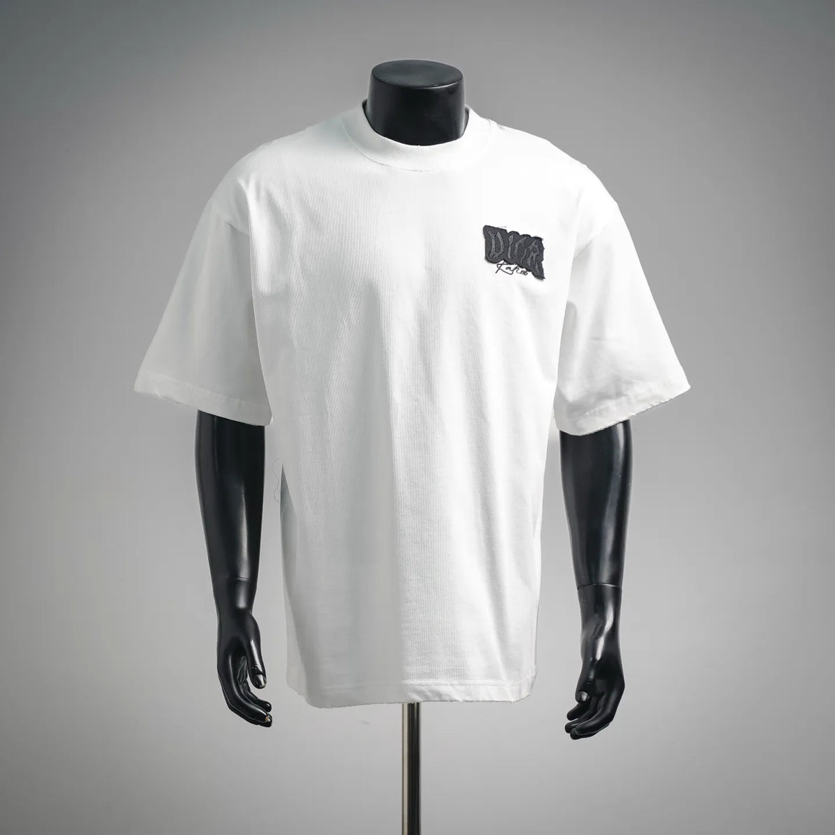White Dior T-shirt on a mannequin, short sleeves, black chest logo patch