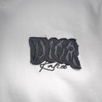 Black Dior embroidered logo patch on a white Dior T-shirt chest