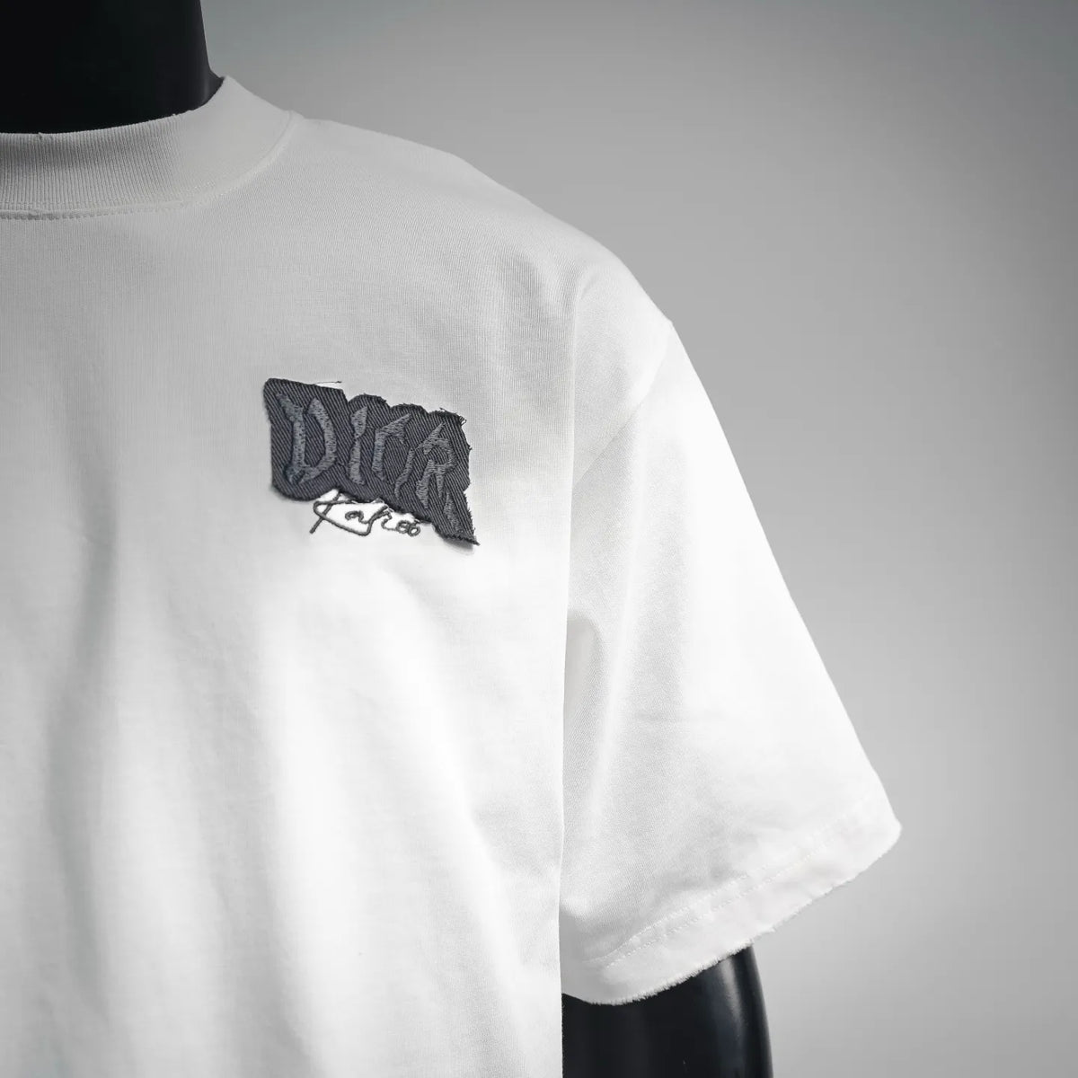 White Dior T-shirt side view with black chest logo patch and short sleeve