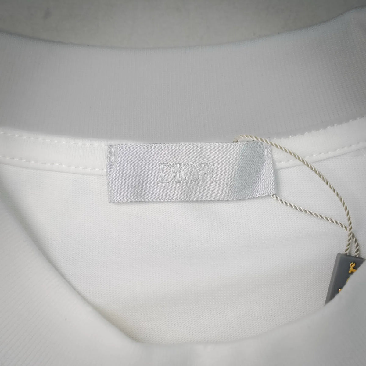 White Dior T-shirt inner neck label with Dior branding and attached fabric tag