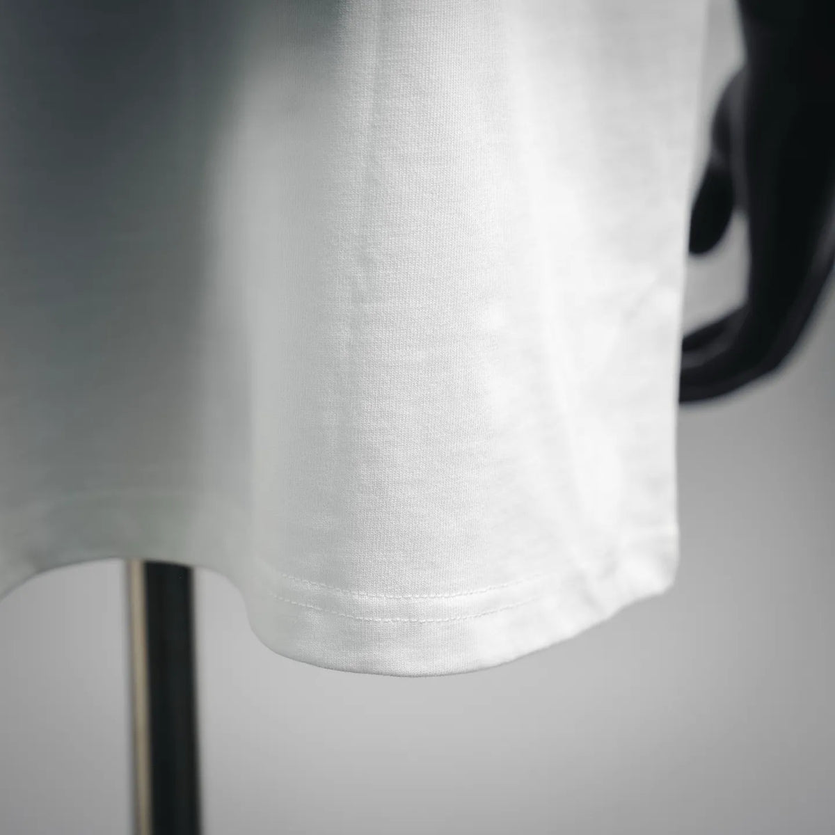 White T-shirt sleeve hem detail with visible seam stitching