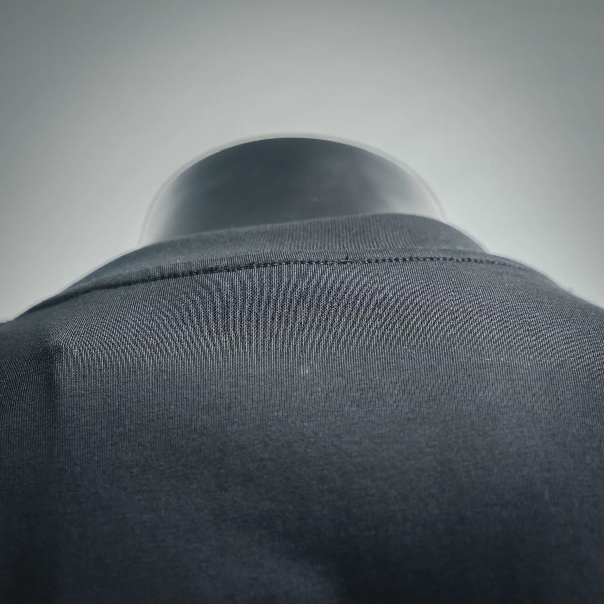 Dior crew-neck T-shirt neckline close-up, dark jersey fabric around collar