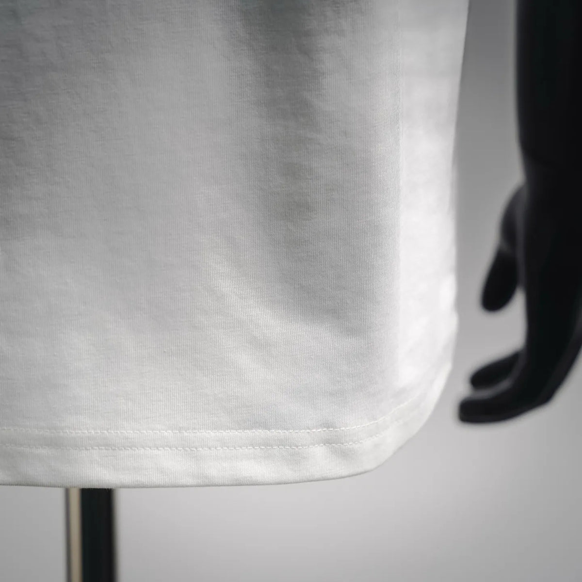 White short-sleeve T-shirt fabric close-up with stitched hem