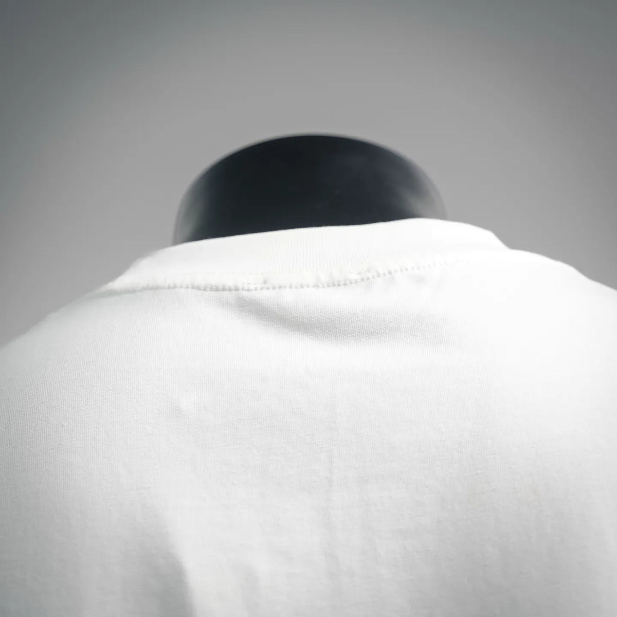 White short-sleeve T-shirt back neckline close-up on a mannequin