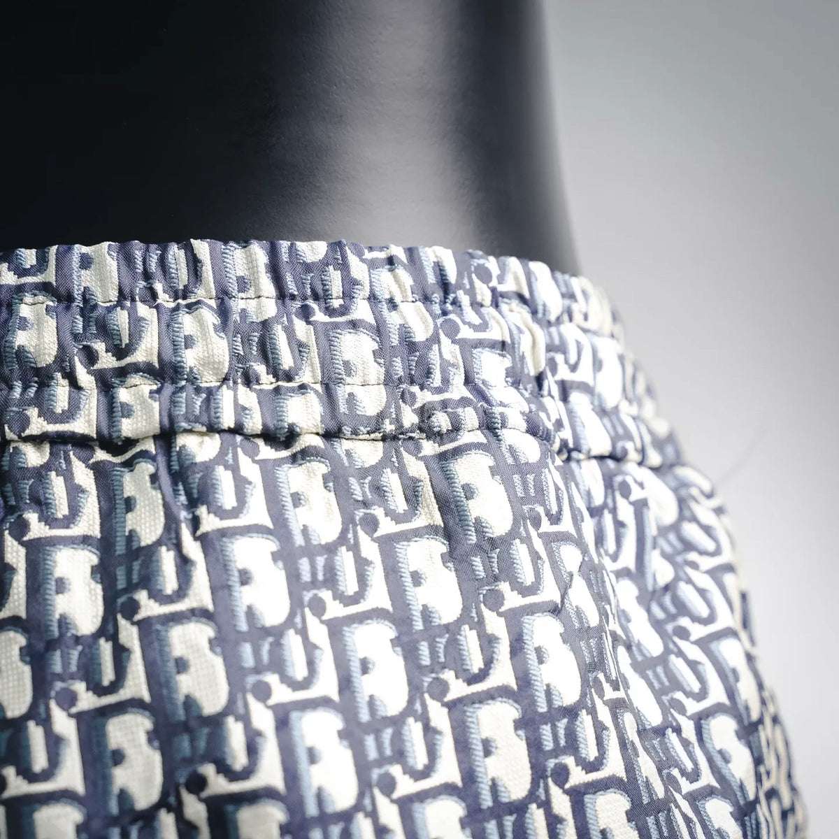 Elastic waistband detail on blue and white Dior logo shorts