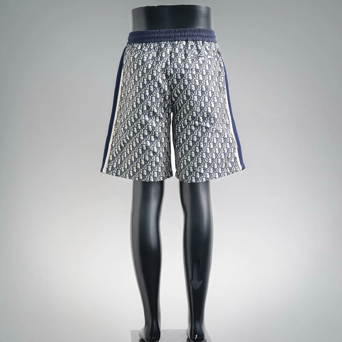 Dior shorts front view, navy-and-cream logo print with elastic waistband