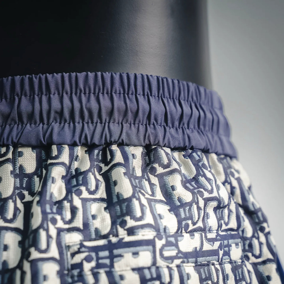 Dior shorts waistband close-up with gathered elastic and logo print