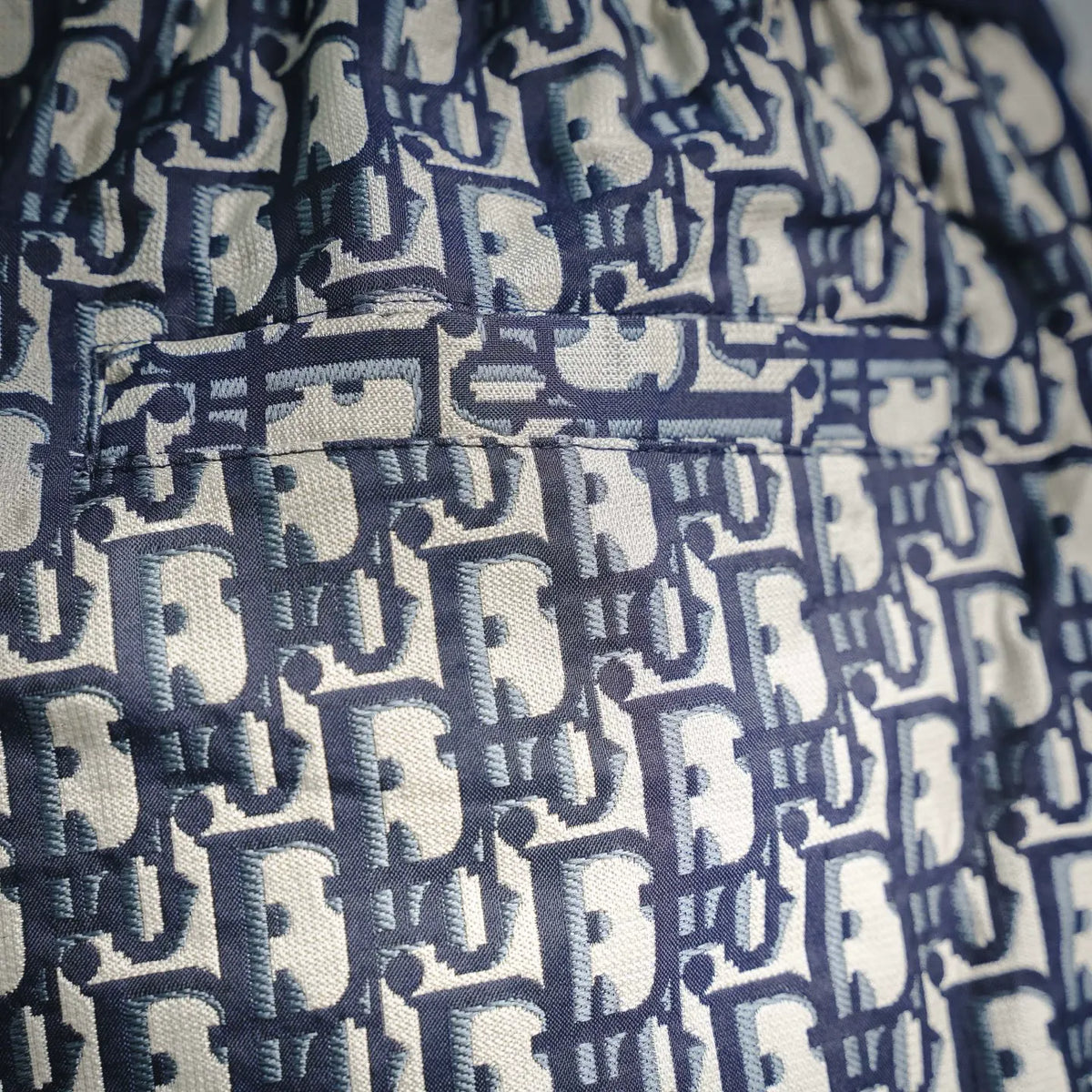 Dior shorts logo pattern close-up in navy and cream