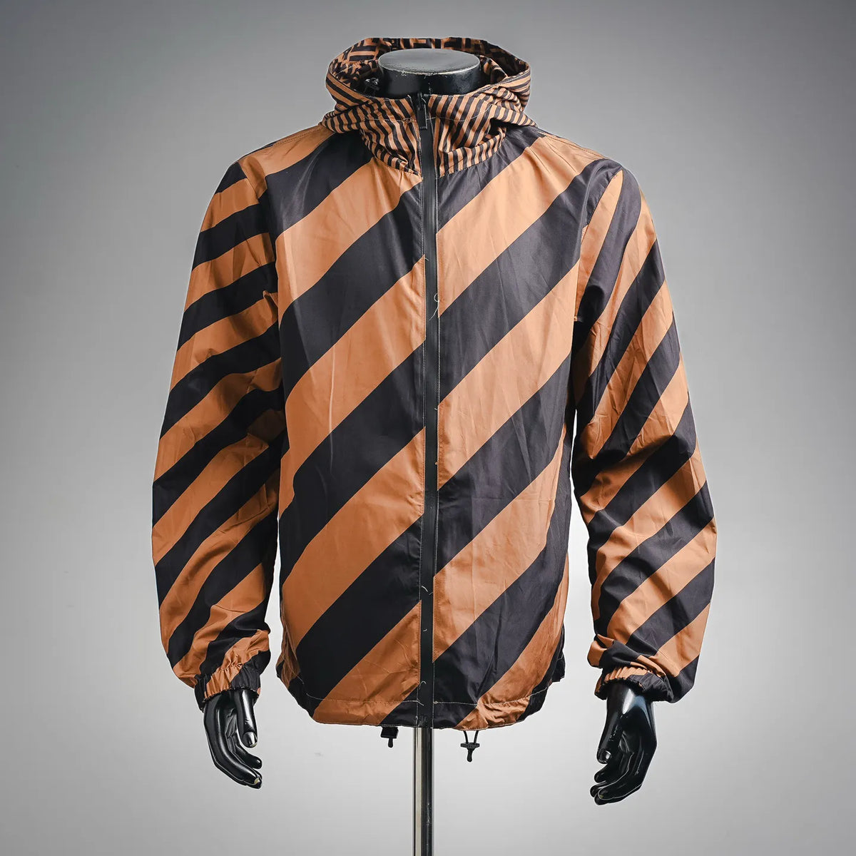 Hooded coat with diagonal striped pattern in tan and dark colors, full zip