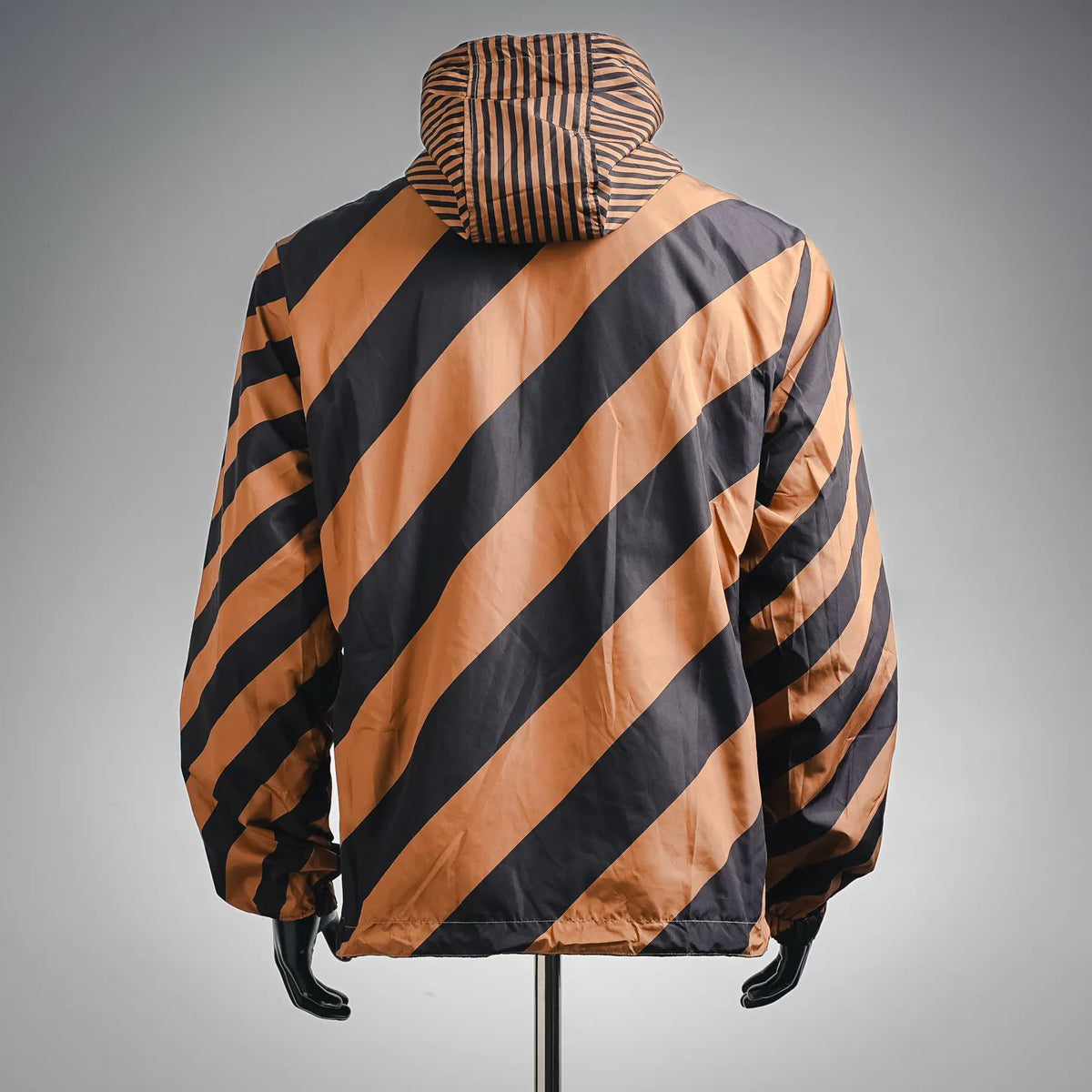 Hooded coat with diagonal striped back in tan and dark panels, full zip