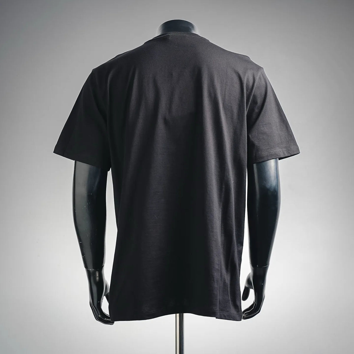Dark crewneck T-shirt with short sleeves, back view on a mannequin.