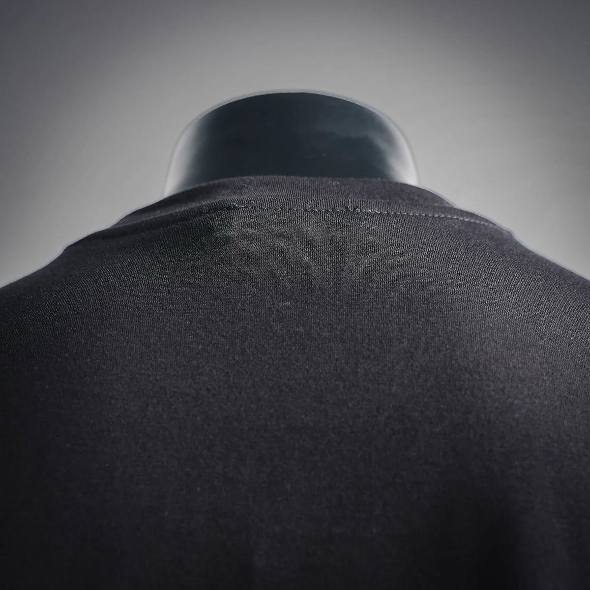 Dark crewneck T-shirt collar seam close-up from the back.