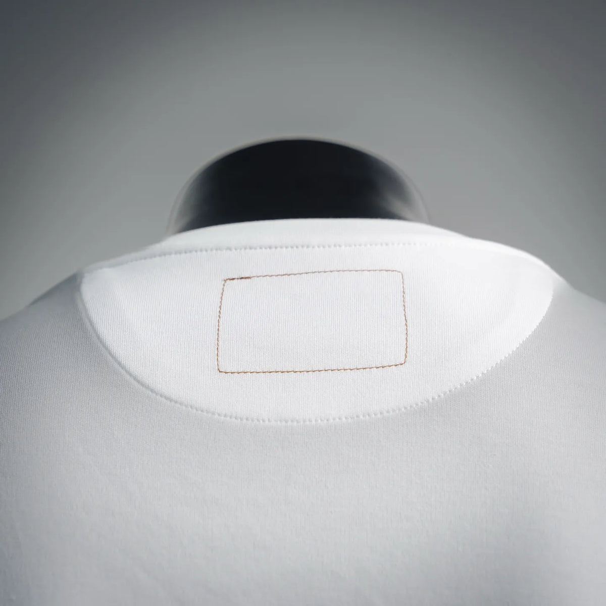 White T-shirt with small rectangular patch at back of neck