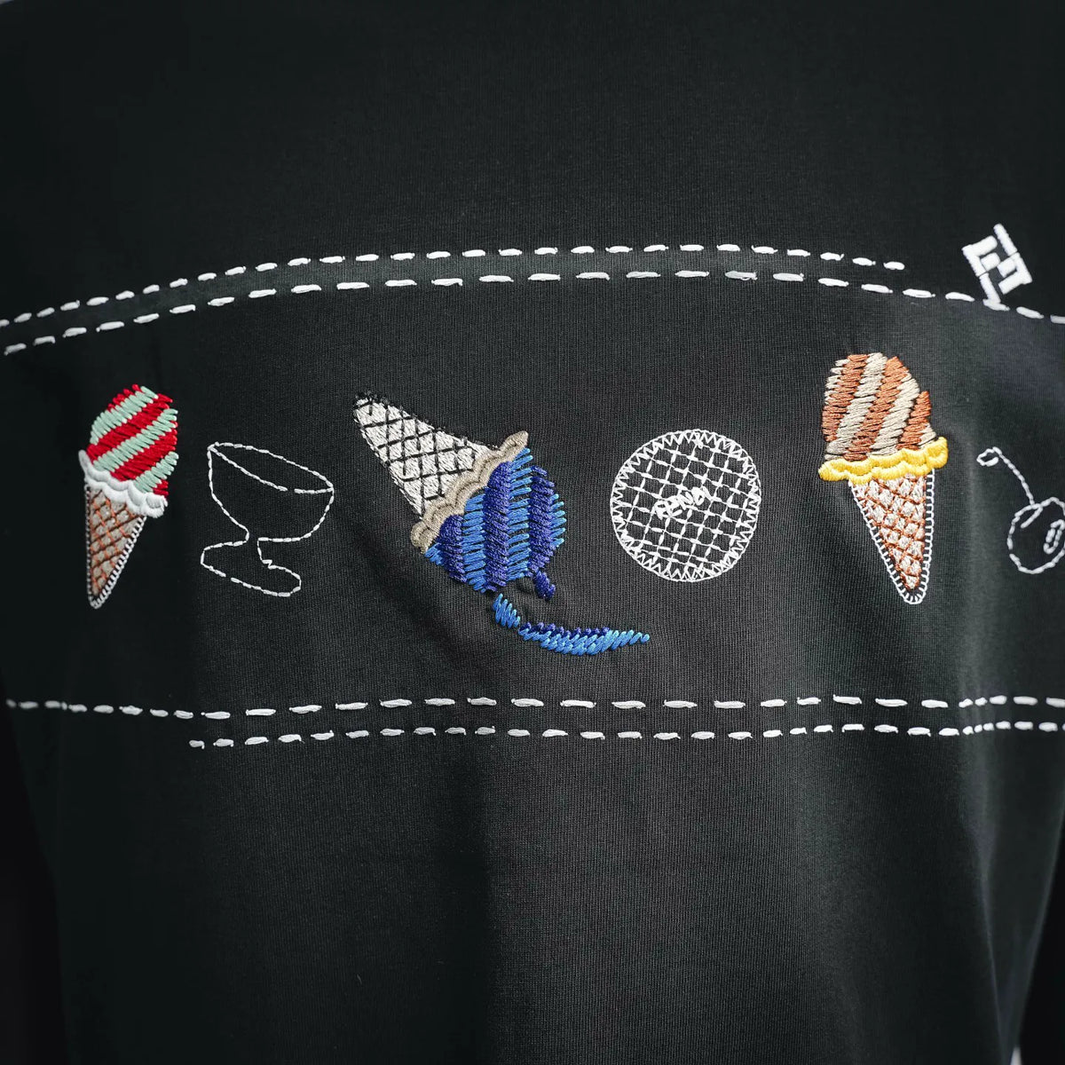 Dark T-shirt with stitched multicolor patches and icons on chest