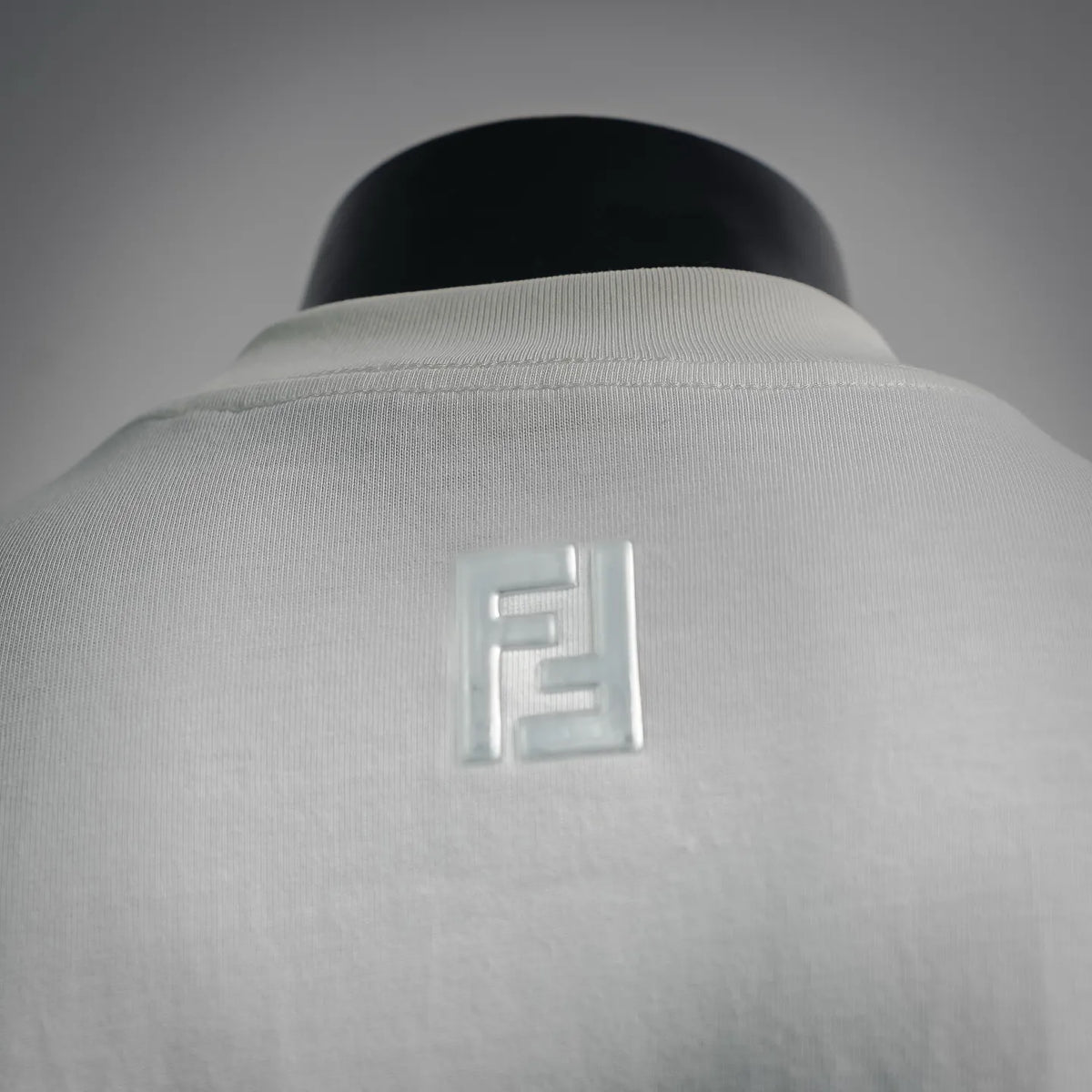 Close-up of white T-shirt back with raised Fendi logo embroidery