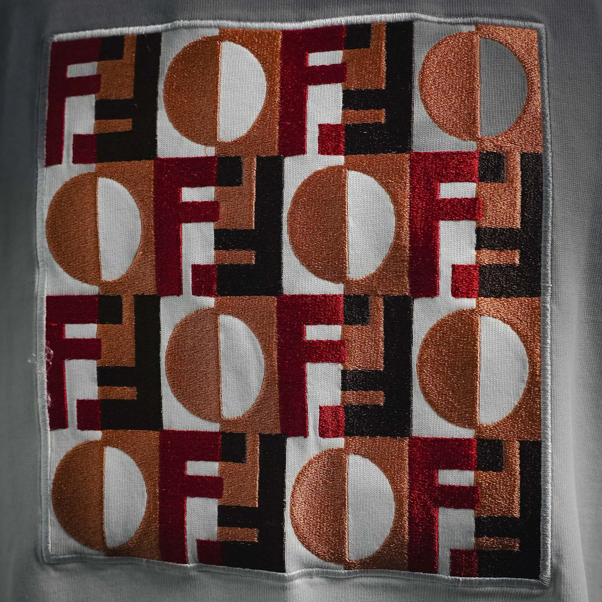 Close-up of multicolor Fendi logo patch graphic on white T-shirt