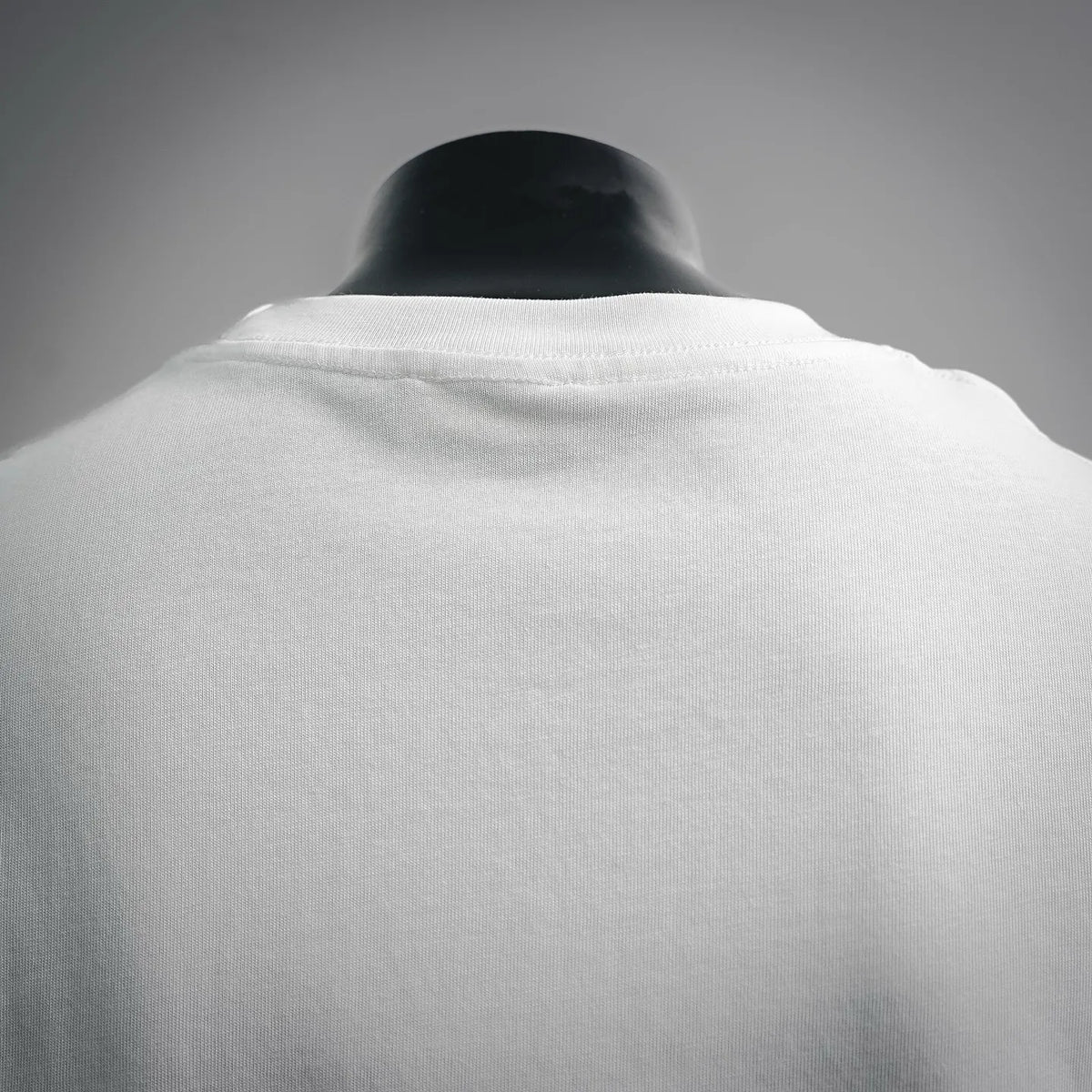 White crewneck T-shirt collar and back shoulder seam close-up.
