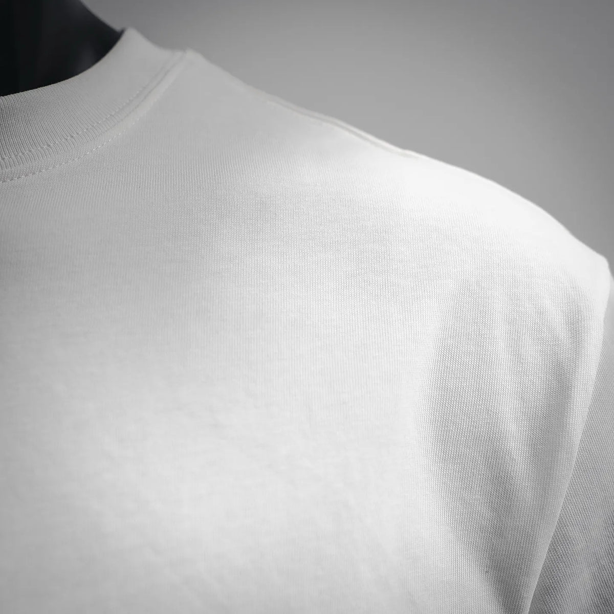 White T-shirt side panel fabric and sleeve shoulder area close-up.