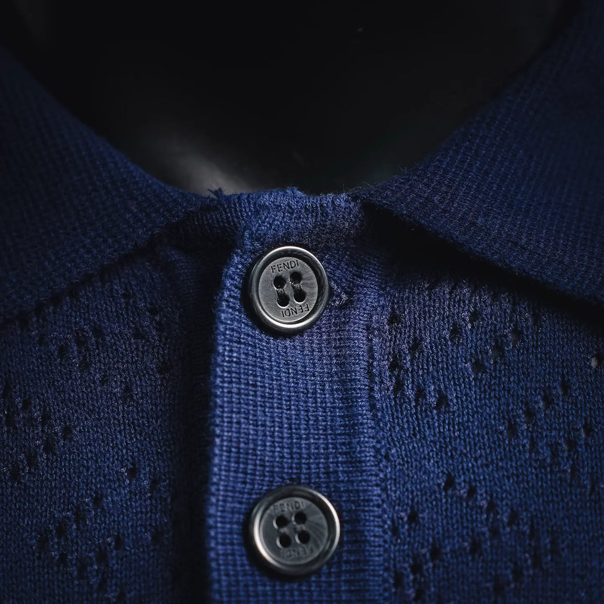 Fendi polo shirt close-up: deep blue knit with two button placket and logo buttons