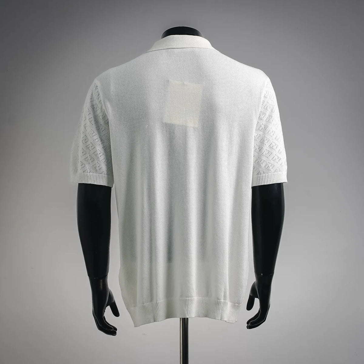 White short-sleeve polo shirt back with textured knit and ribbed cuffs.