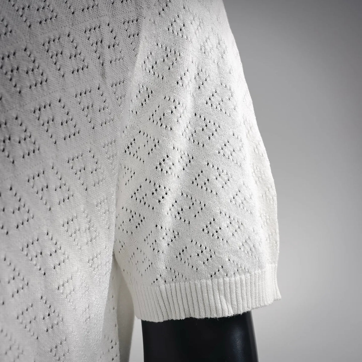 White knit polo sleeve with ribbed cuff and diamond pattern texture.