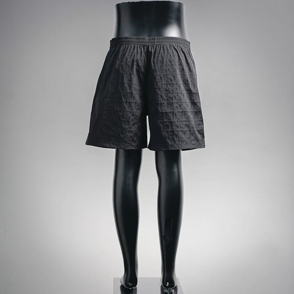 Black drawstring shorts on mannequin, back view