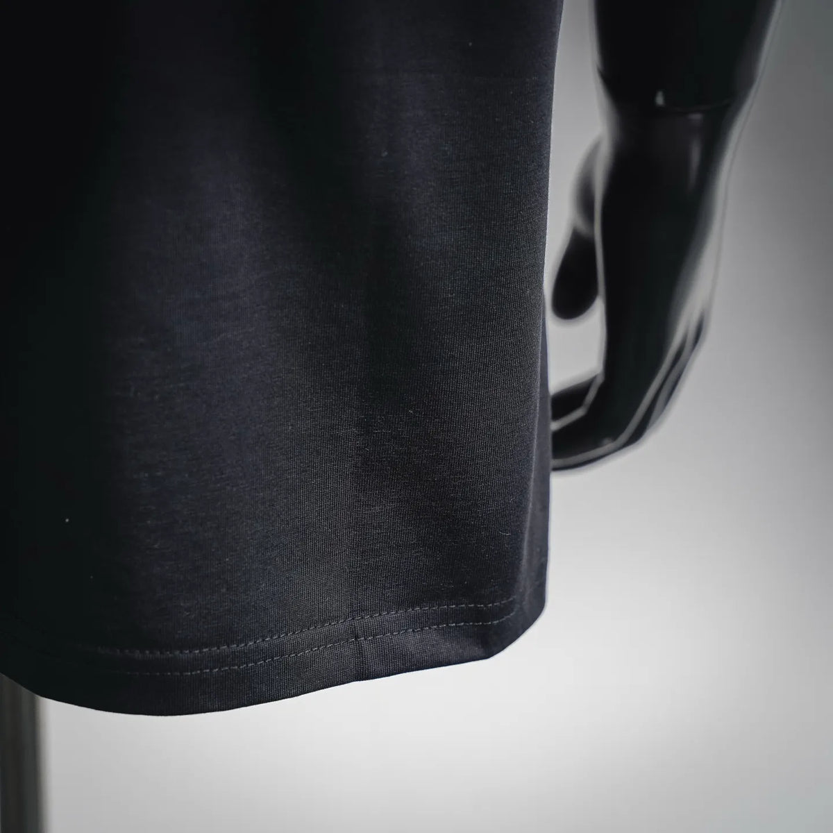 Black T-shirt hem close-up with stitched bottom edge