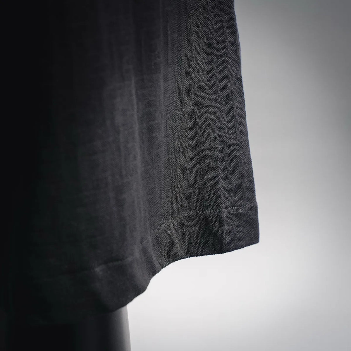 Black textured fabric with subtle woven pattern on shorts