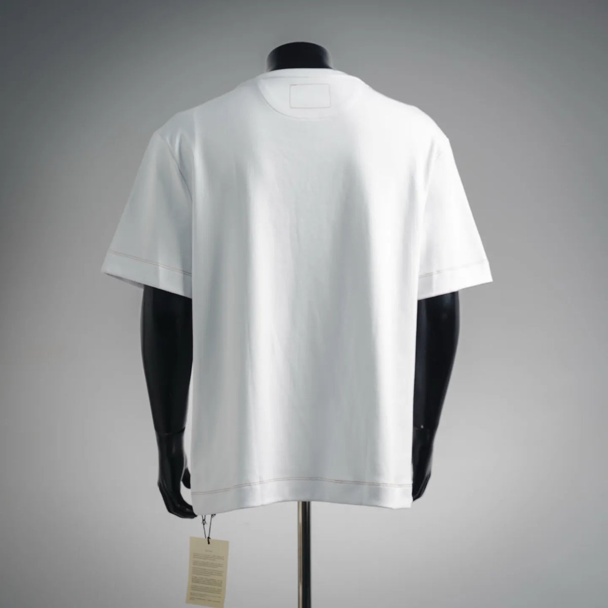 White short-sleeve T-shirt on mannequin, back view with small square label patch