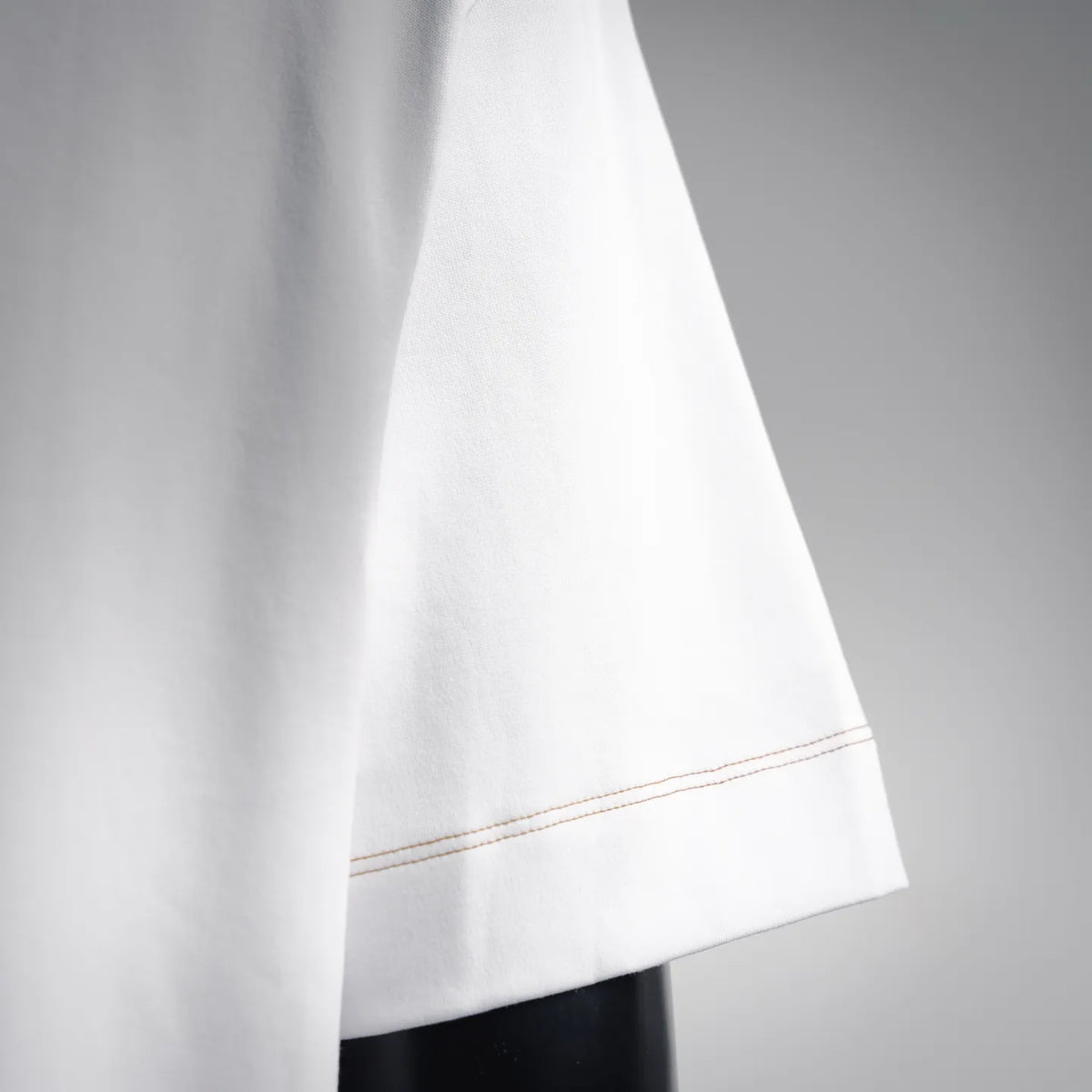 White short-sleeve T-shirt hem with thin contrast stitching detail