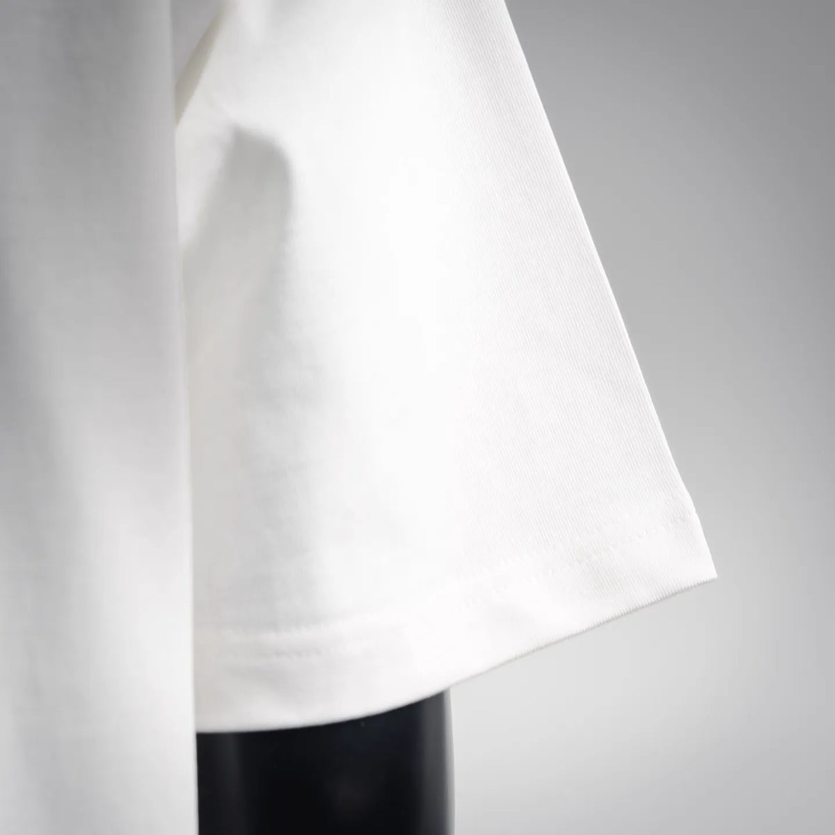 White Fendi short-sleeve T-shirt side view with smooth fabric and curved hem.