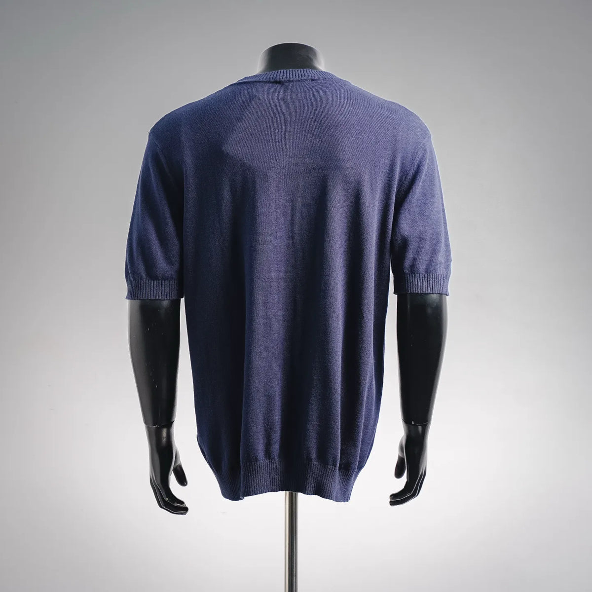 Back view of blue knit crewneck sweater with ribbed cuffs and hem
