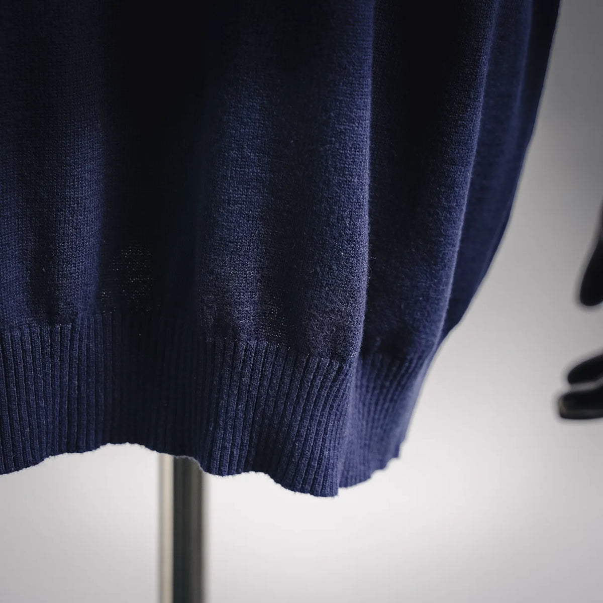 Close-up of blue knit sweater hem and ribbed bottom cuff