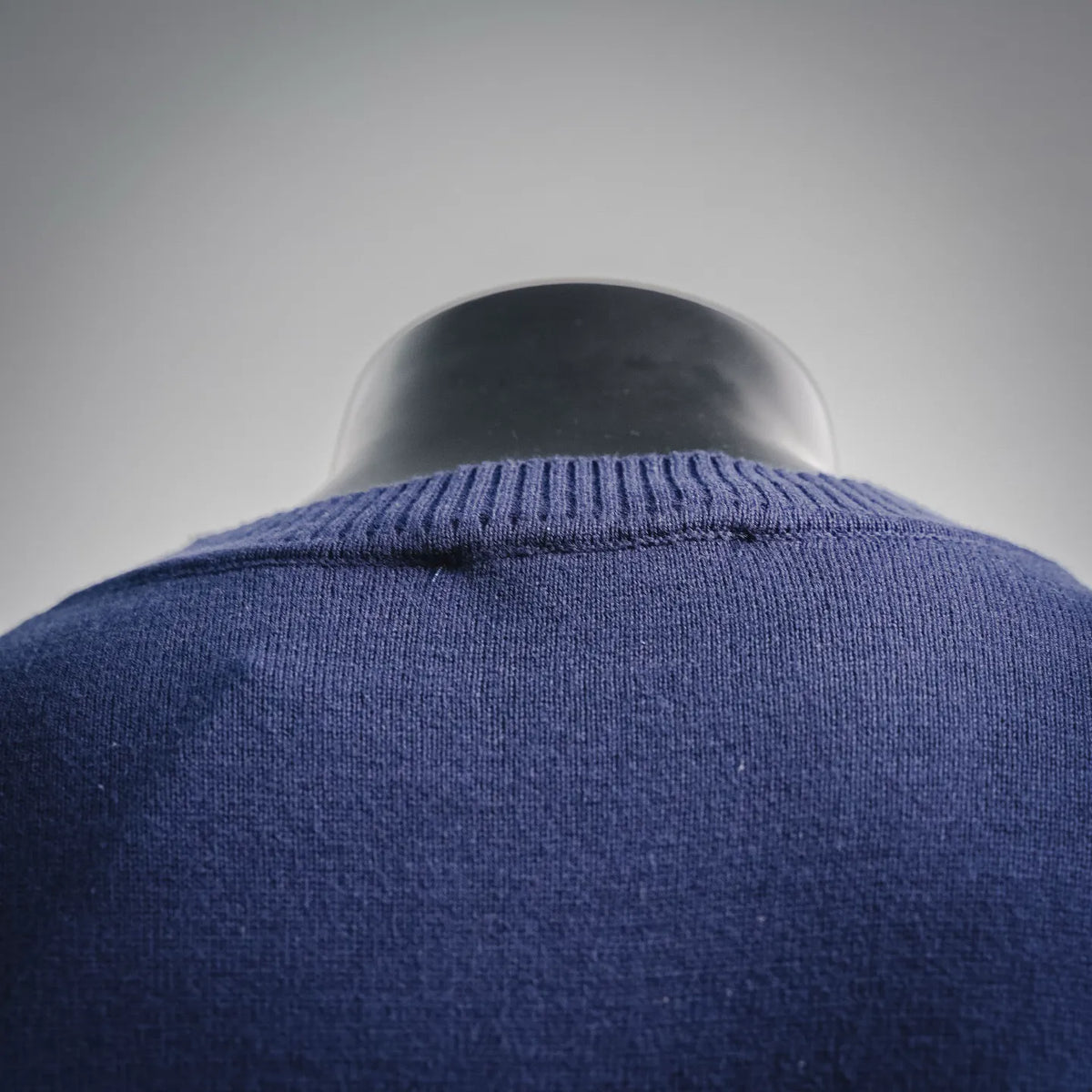 Close-up of blue crewneck sweater neckline with ribbed collar