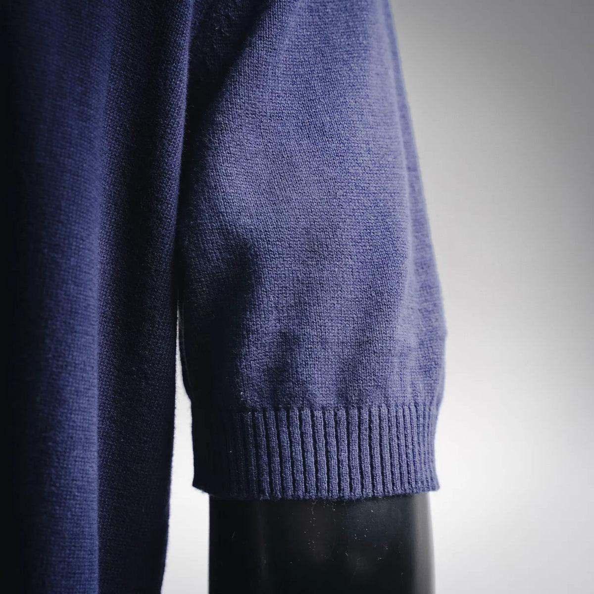Close-up of blue knit sweater sleeve with ribbed cuff