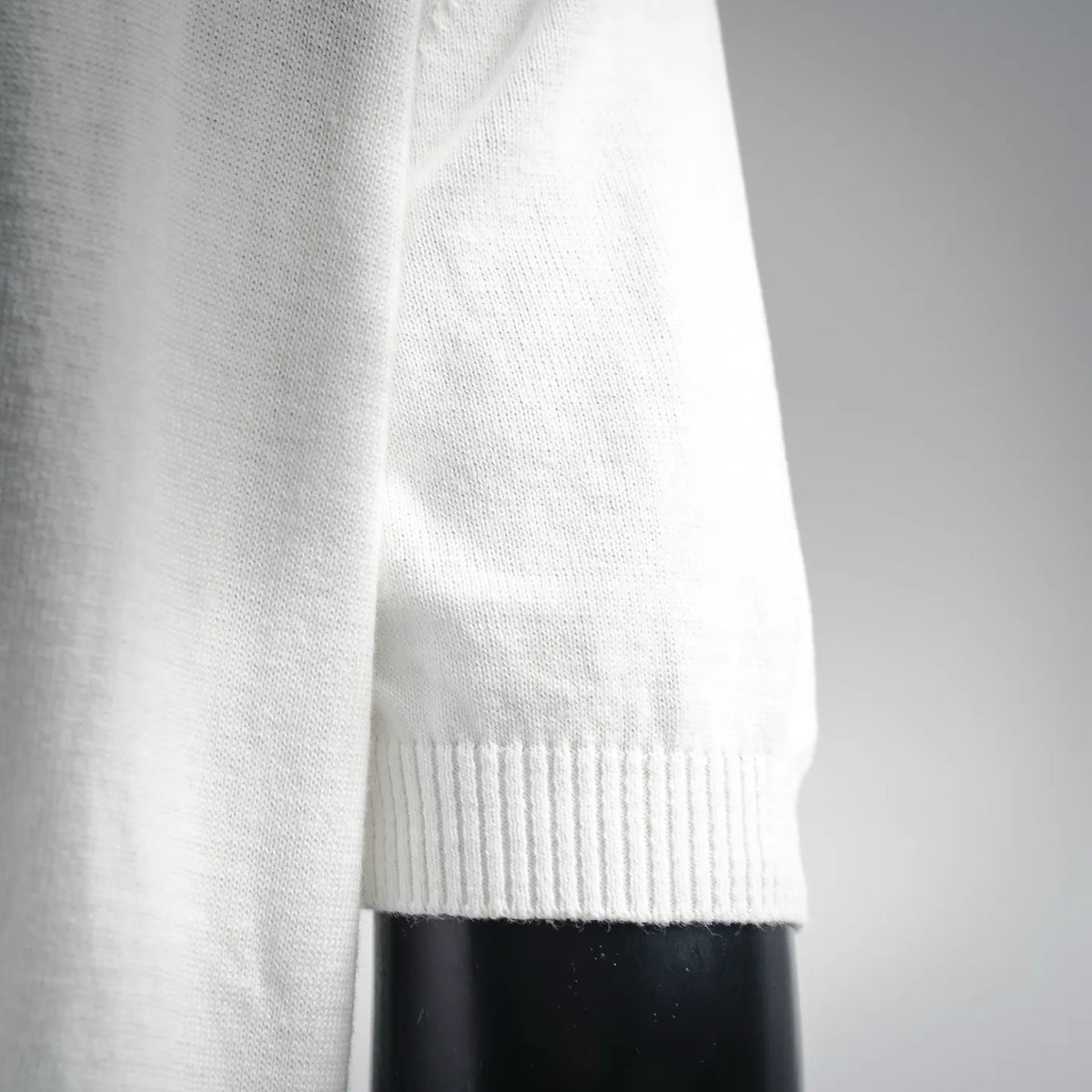 White knit sweater sleeve with ribbed cuff and smooth knit texture