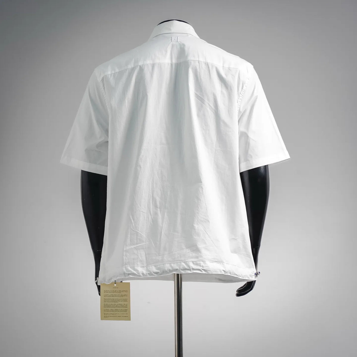 White short-sleeve button-up shirt, back view with yoke seam and pleats