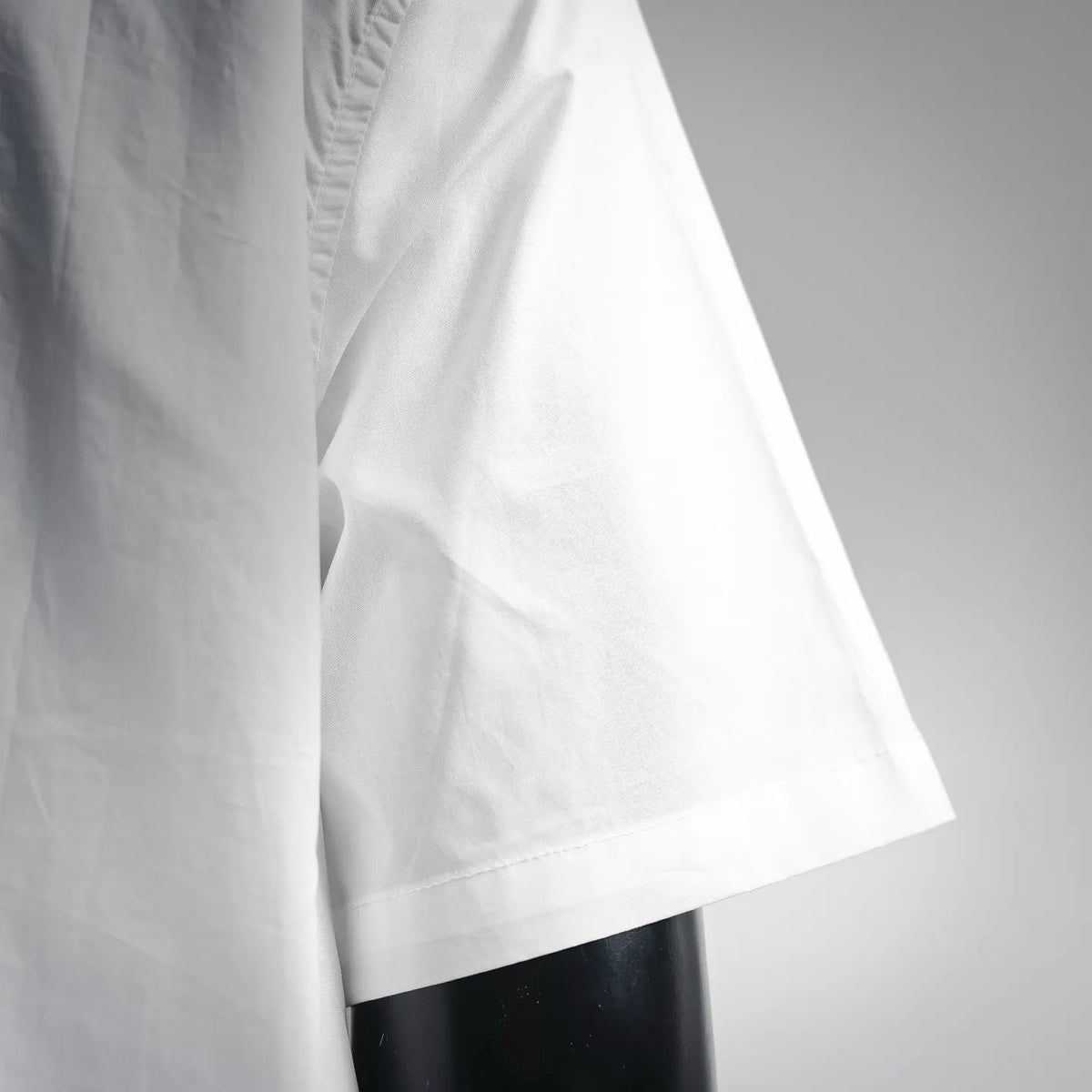 White short-sleeve shirt with curved hem and side panel seam