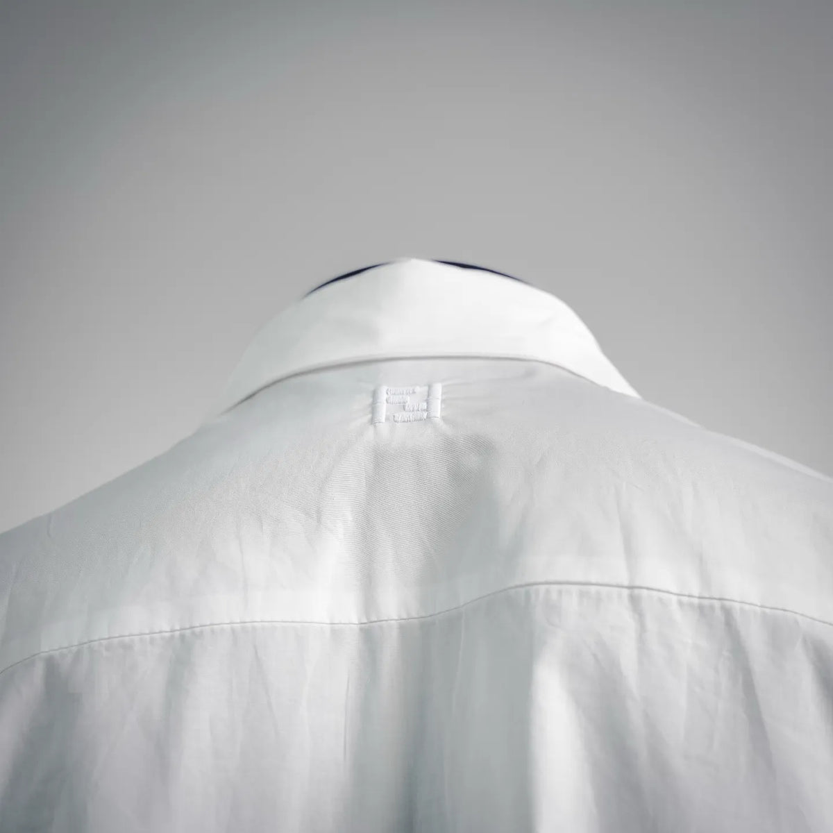 White shirt collar and back yoke seam with care label