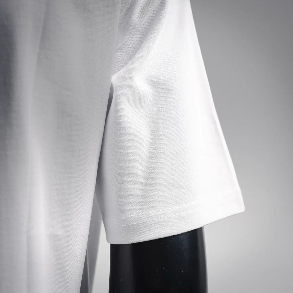 White short-sleeve T-shirt sleeve and side with visible fabric texture